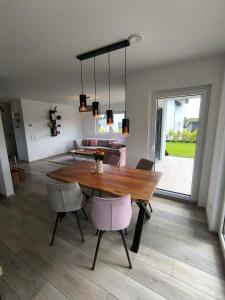 a dining room and living room with a table and chairs at VILLA VULKANEIFEL -modern -familienfreundlich -Terrasse -Doppelgarage -ruhiger Lage in Darscheid