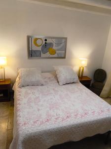 a bedroom with a white bed with two lamps at "Le Mas" Les jardins de Tourneige in Maraussan +32 photos