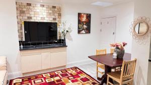 a living room with a table and a tv at Panthea Home in Barkingside