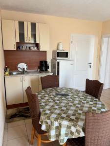 a kitchen with a table and chairs and a kitchen with a sink at Milchevi Guesthouse in Sozopol