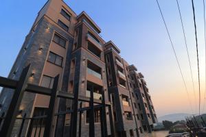 a tall building with many windows on a street at Abrish Hotel and Apartment in Kampala