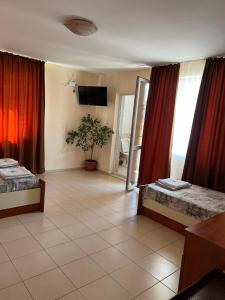 a hotel room with two beds and a television at Milchevi Guesthouse in Sozopol