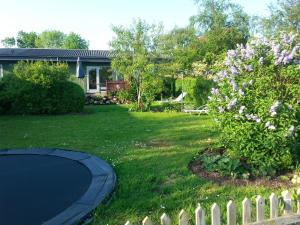 a yard with a fence and a garden with a tree at Holiday Home Kirkeby Feriehus in Roslev