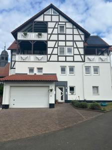una casa bianca e nera con garage di Preiswerte Ferienwohnung a Neukirchen
