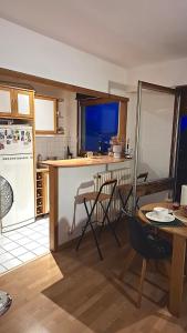 una cucina con un tavolo e una cucina con un frigorifero di Chic studio with balcony! a Clamart Altre 16 foto
