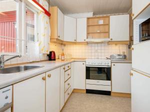 a kitchen with white cabinets and a sink at 4 person holiday home in Haderslev in Haderslev +13 photos