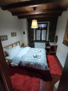 a bedroom with a large bed with a red rug at Villa Aretousa in Palaios Agios Athanasios