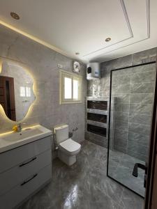 a bathroom with a toilet and a sink and a shower at Luxury appartment New Cairo in New cairo +25 photos