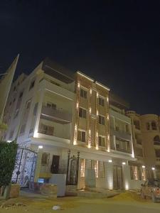 a large building with lights on it at night at Luxury appartment New Cairo in New cairo
