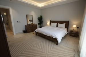 リヤドにあるMajdiya 125 King Salman Dist 2BR Gym Poolの大きなベッドと2つのナイトスタンドを備えた寝室 +12枚の写真