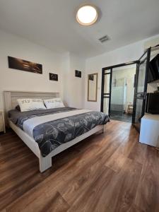 a bedroom with a large bed and a wooden floor at Queen Indulgent suites for couples in Qiryat Ata