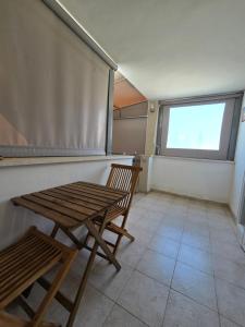 a table and chairs in a room with a window at Queen Indulgent suites for couples in Qiryat Ata