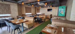 a restaurant with tables and chairs in a room at Hotel Amulya Royal Inn in Bangalore