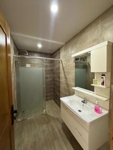 a bathroom with a sink and a shower at T5 spacieux et lumineux in Bir el Djir +2 photos
