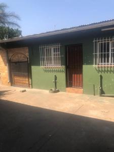 ケンプトンパークにあるChristland Guest Houseの側面に2つのドアがある緑色の建物