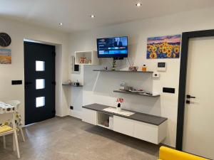 a living room with a tv on the wall at Appartamento Pineta casa vacanze Sci & Natura in Varena +31 photos