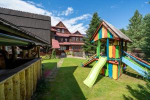 a playground with a slide and a house at U Chowańca in Murzasichle