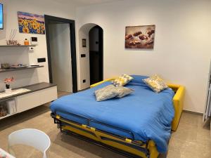a bedroom with a bed with blue sheets and pillows at Appartamento Pineta casa vacanze Sci & Natura in Varena