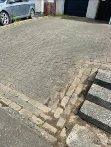 ein gemauerter Parkplatz mit einem Schatten auf dem Boden in der Unterkunft Cosy Home with Free Parking Near Edinburgh St Andrews M90 & Amazon in Dunfermline