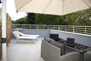 a patio with a table and chairs and an umbrella at The Three Diamonds - B&B CESENATICO in Cesenatico