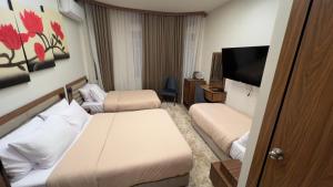 a hotel room with two beds and a flat screen tv at Excellent Location cairo in Cairo