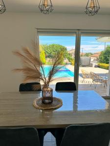 a dining room table with a vase on it at Logement indépendant avec piscine privée in Penta-di-Casinca