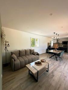 a living room with a couch and a table at Logement indépendant avec piscine privée in Penta-di-Casinca