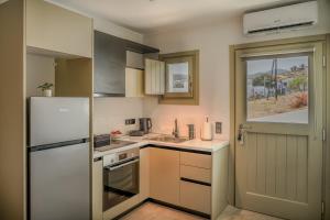 a kitchen with a white refrigerator and a sink at Apademia Comfort Studio 45 sqm in Skiros +10 photos