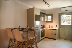 a kitchen with a table and chairs in a kitchen at Apademia Comfort Studio 45 sqm in Skiros