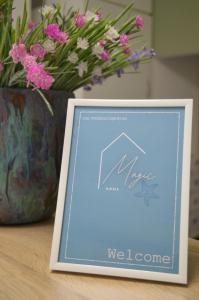 ein Bilderrahmen neben einer Vase mit Blumen in der Unterkunft Magic Home in Ceriale