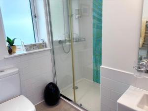 a bathroom with a shower and a toilet and a sink at Sunsets, Sandylands Prom Morecambe in Morecambe