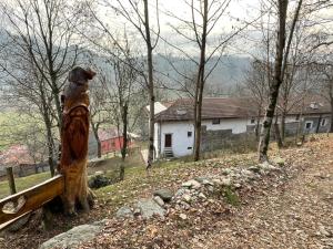 a wooden statue of a dog sitting on a bench at Country Cottage by LePigne World in Ameno