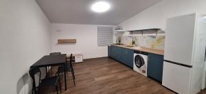 a kitchen with a refrigerator and a table and a washing machine at Park Residence in Hoghiz