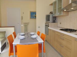 a kitchen with a table and orange chairs in a kitchen at Holiday Home in Lazise near Lake Garda in Lazise