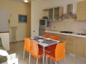 a kitchen with a table and orange chairs in it at Holiday Home in Lazise near Lake Garda in Lazise