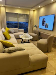 a living room with a couch and a flat screen tv at Luxe appartement in Bouznika
