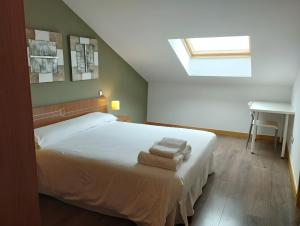 a bedroom with a bed with two towels on it at Ático Vista Alegre in Lerma