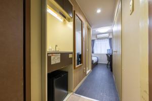 a hallway leading to a room with a bathroom at Sleep Inn Gotanda in Tokyo +99 photos