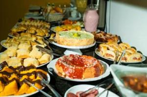 a table full of different types of food on plates at Pousada Michele in Morro de São Paulo