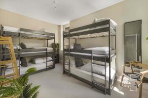 a room with three bunk beds with white pillows at Luxe Ami Beh Large Group Apartment by PolkaStays in Blackpool