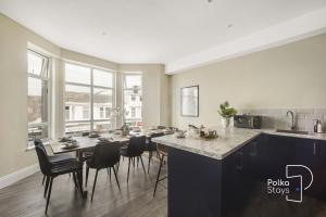 a kitchen with a table and chairs in a room at Luxe Ami Beh Large Group Apartment by PolkaStays in Blackpool