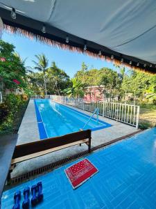 a swimming pool with a bench in front of it at Barracuda Swim Club's Homestay - Fan Room with Pool in Coron