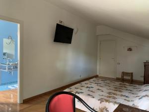 une chambre avec un lit et une télévision sur un mur dans l'établissement Villa Irim tra il mare e la montagna, 