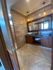 un baño con lavabo y espejo en Kubung Hill Views uluwatu, en Uluwatu 17 fotos más