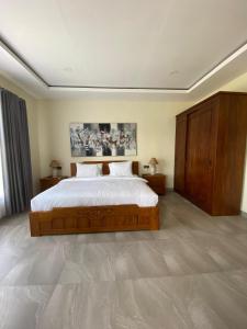 Un dormitorio con una cama grande con sábanas blancas. en Kubung Hill Views uluwatu, en Uluwatu