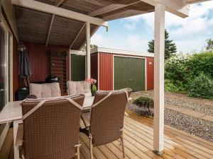 EgernsundにあるSpacious Retreat in Rendbjerg-By Traumのデッキにテーブルと椅子が置かれたパティオ