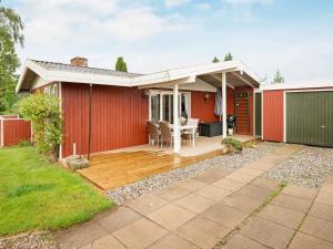 EgernsundにあるSpacious Retreat in Rendbjerg-By Traumの木製デッキ(テーブル付)のある家
