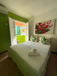 a bedroom with a bed with a painting on the wall at Pousada Michele in Morro de São Paulo
