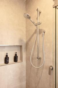 a shower with a shower head in a bathroom at CBD 2 Bed 2 Bath Luxury Gem With Free Car Park in Christchurch +39 photos