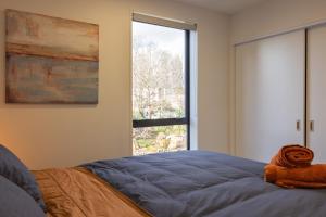 a bedroom with a bed and a large window at CBD 2 Bed 2 Bath Luxury Gem With Free Car Park in Christchurch